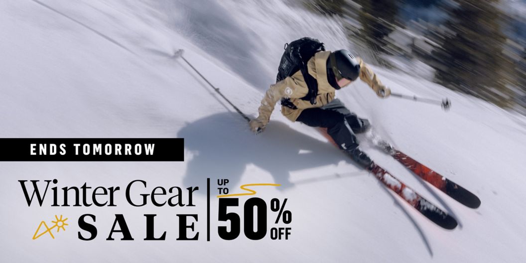 A skier comes down a mountain kicking up snow behind him. A lockup reads “New brands added, Winter Gear Sale, up to 50% off.”